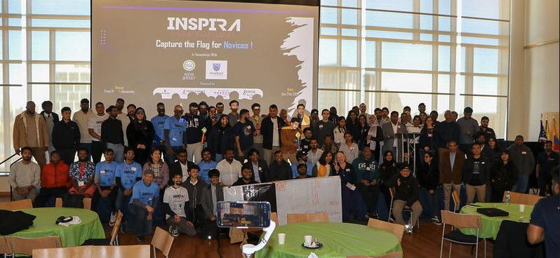 A diverse group of people collaborating around a table with laptops.
